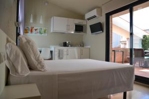 マルグラット・デ・マルにあるApartamento playa Costa Barcelonaのベッドルーム(白いベッド1台付)、キッチン