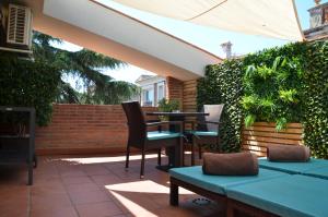 a patio with tables and chairs and a hedge at Apartamento playa Costa Barcelona in Malgrat de Mar