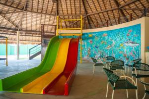 a slide in a play room with a mural at Sun City Rota das Emoções in Camocim