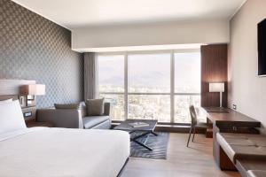 a hotel room with a bed and a couch and a desk at AC Hotel by Marriott Santiago Costanera Center in Santiago