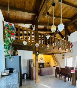 a living room with wooden ceilings and a table and chairs at La Casetta - O întreagă căsuță ca în povești in Baia-Sprie