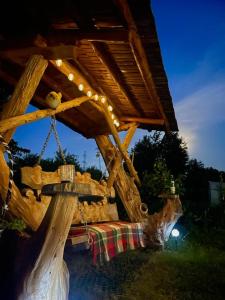 a wooden structure with a table and a swing at La Casetta - O întreagă căsuță ca în povești in Baia-Sprie