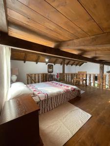 ein Schlafzimmer mit einem Bett und einer Holzdecke in der Unterkunft La Casetta - O întreagă căsuță ca în povești in Baia Sprie