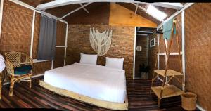 a bedroom with a bed in a brick wall at Hub Tata Guesthouse in Tuk Tuk