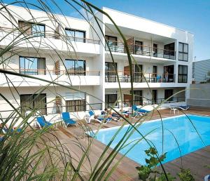 un hotel con piscina frente a un edificio en Résidence Odalys Archipel, en La Rochelle