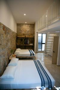 2 camas en una habitación con una pared de piedra en Yauik, en Tequesquitengo