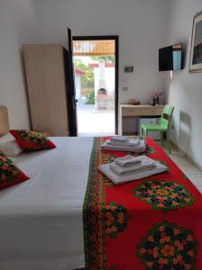 a bedroom with a large bed with a red blanket at B&B Villa VITTORIO in Galatone