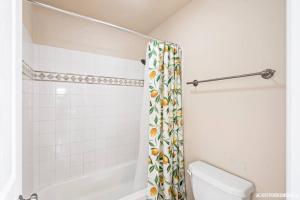 a bathroom with a toilet and a shower curtain at Alaska Townhouse Getaway: Anchorage Cozy Retreat - Close to Downtown in Anchorage