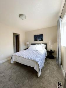 a white bedroom with a bed and two lamps at Alaska Townhouse Getaway: Anchorage Cozy Retreat - Close to Downtown in Anchorage