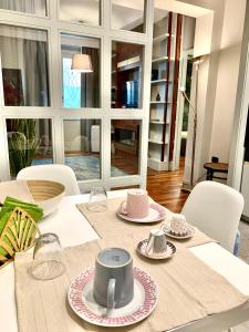 einen Esstisch mit weißen Stühlen und einem weißen Tischtuch in der Unterkunft Maison barbuti in Salerno
