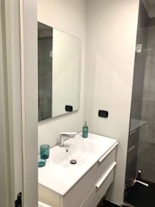 ein weißes Badezimmer mit einem Waschbecken und einem Spiegel in der Unterkunft Maison barbuti in Salerno