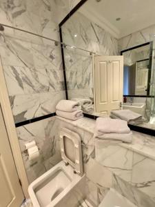 a marble bathroom with a sink and a mirror at Top floor luxury 3 bedroom near Baker St in London