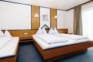 a hotel room with two beds and a window at Hotel Garni Tannenhof in Flachau