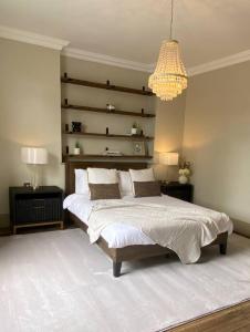 a bedroom with a large bed and a chandelier at Top floor luxury 3 bedroom near Baker St in London