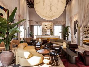 a lobby with couches and tables and a large clock at Nobis Hotel Palma, a Member of Design Hotels in Palma de Mallorca