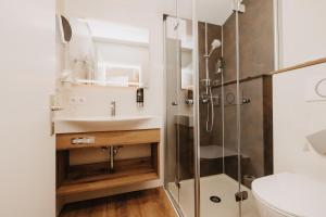 een badkamer met een douche en een wastafel bij Hotel Garni Tannenhof in Flachau