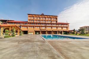a large building with a swimming pool in front of it at Zedazeni Hotel in Mtskheta