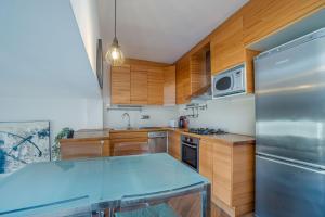 une cuisine avec des armoires en bois et un réfrigérateur en acier inoxydable dans l'établissement ref 403, à Empuriabrava 20 autres photos