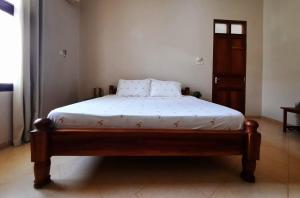 um quarto com uma cama com lençóis brancos e uma janela em Modern apartment in Stone Town em Stone Town