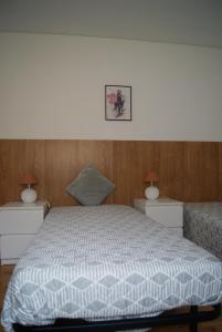 a bedroom with a white bed with two night stands at Aguieira STAY in Castro Daire
