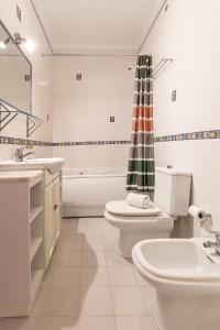 ein Badezimmer mit Waschbecken, Toilette und Badewanne in der Unterkunft Seaside Deluxe Flat in Peniche