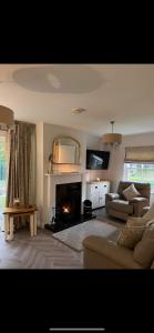 uma sala de estar com um sofá e uma lareira em Bunratty Castle Gardens em Bunratty