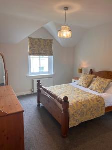 a bedroom with a bed and a window and a chandelier at Bunratty Castle Gardens in Bunratty