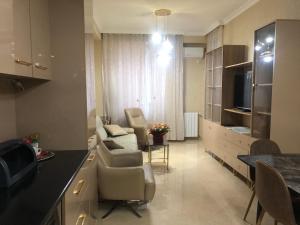 een keuken en een woonkamer met stoelen en een tafel bij the best apartment in Koetaisi