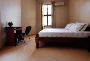 a bedroom with a bed and a desk and a window at Modern apartment in Stone Town in Stone Town