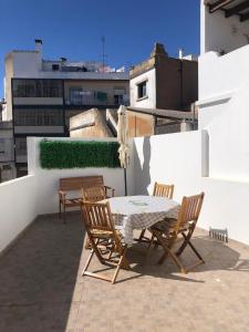 un patio con mesa y sillas en la azotea en Blue Sardine Hostel en Portimão