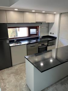 eine Küche mit weißen Schränken und einer schwarzen Arbeitsplatte in der Unterkunft CASA RIO VEZ - Riverfront in Arcos de Valdevez