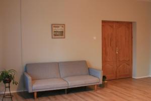 un sofá en una sala de estar con puerta de madera en Brīvdienu māja Tobago, en Plieņciems