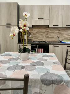 una cucina con tavolo e fiori di Casa Filomena a Vibo Valentia
