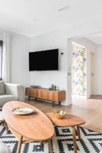 een woonkamer met 2 tafels en een flatscreen-tv bij Home2Book Casa Boissier, Breakfast Included in Las Palmas de Gran Canaria