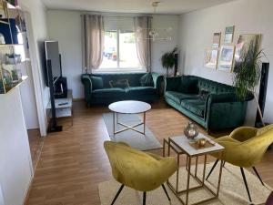a living room with a green couch and chairs at Swden Sunne in Sunne