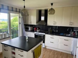 a kitchen with white cabinets and a black counter top at Swden Sunne in Sunne