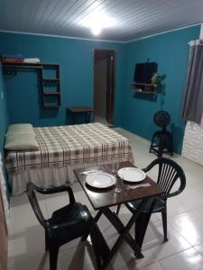 a room with a bed and a table and chairs at Kitnet Arretada São João in Campina Grande
