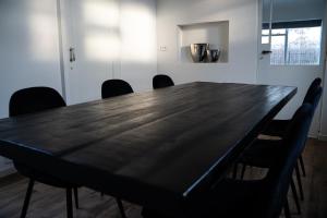 una sala de conferencias con mesa negra y sillas en Kess Maison, Gehele villa met dakterras Enschede, en Enschede