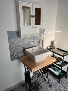 La salle de bains est pourvue d'un lavabo blanc sur une table en bois. dans l'établissement Bezauberndes Häuschen auf historischer Hofstelle, 