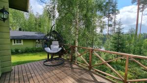 a porch with a swing on a wooden deck at Villa Helmi in Jämsä