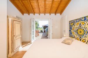 een slaapkamer met een bed en een open deur bij Gotas de Luar Turismo Rural in Vila Nova de Milfontes