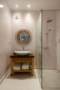y baño con lavabo y espejo. en Luxurious Santorini Escape - Villa Imerovigli - Infinity Pool - Breathtaking Aegean Views, en Vourvoúlos