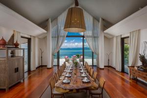 una lunga sala da pranzo con un lungo tavolo e sedie di Villa Arun a Phuket
