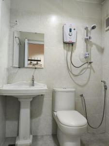 ein Bad mit einem WC, einem Waschbecken und einer Dusche in der Unterkunft Ar Rayyan Hotel in Tanah Rata