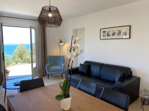 a living room with a black couch and a table at La Citadelle Appartements in Saint-Florent