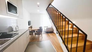 a kitchen with a staircase and a table and chairs at Apolo71 Alojamentos in Bragança