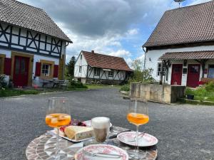 deux verres de vin sur une table devant une maison dans l'établissement Bezauberndes Häuschen auf historischer Hofstelle, 