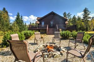 a group of chairs around a fire pit in front of a house at Spacious Twin Mountain Vacation Rental on 5 Acres! in Twin Mountain