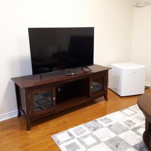 a flat screen tv sitting on top of a wooden entertainment center at in beacon hill in Ottawa