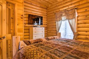 a bedroom with a bed and a window in a log cabin at Spacious Twin Mountain Vacation Rental on 5 Acres! in Twin Mountain